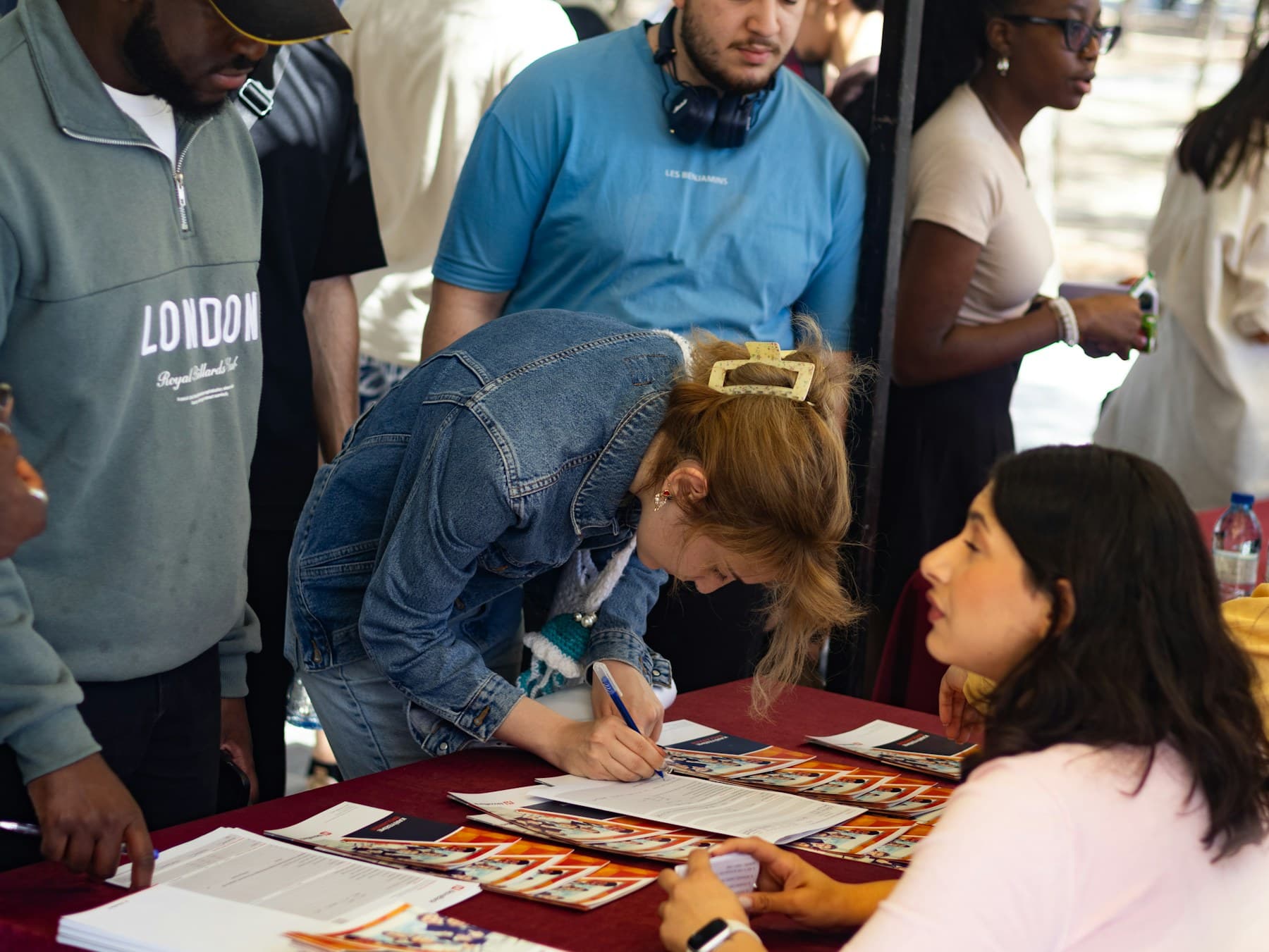 Attendees signing in at an outdoor event registration table