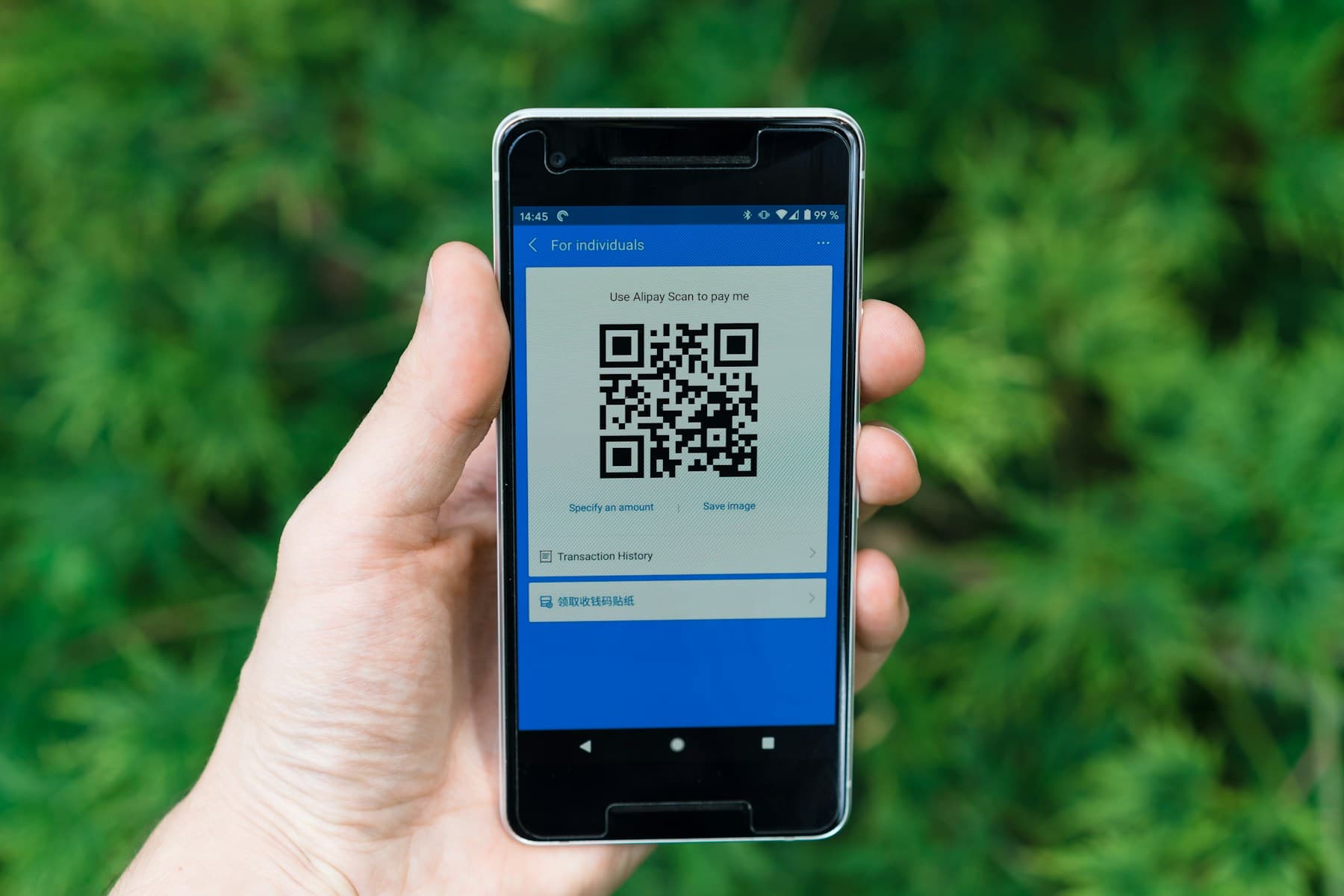 Hand holding a smartphone that displays a QR code to open a form