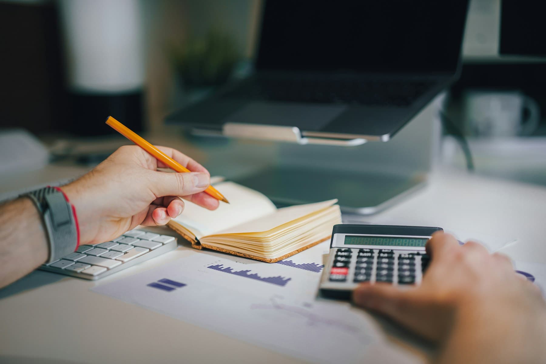 Person planning a survey sample with a calculator and notebook